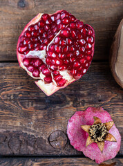 half cut of red, ripe pomegranate on wooden background