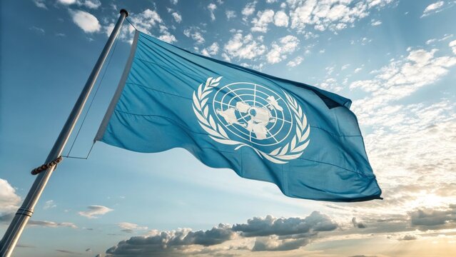 United Nations Flag in the Wind: Capturing a sense of unity and global cooperation, this image showcases the iconic United Nations flag waving proudly against a dynamic, sun-drenched sky. 