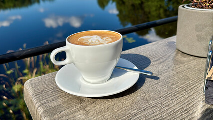cappuccino cup on a sunny summer restaurant terrace