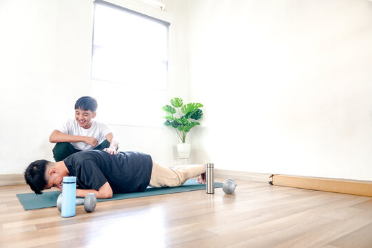 Two Twin Brothers Doing Exercises With Doing Plank On Yoga Mat At Home - Powered by Adobe