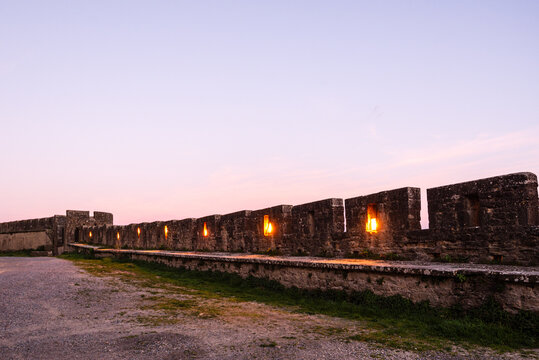 Dusk over the illuminated crenellated walls of Rue de la Barbacane in the fortified Cite de Carcassonne, France