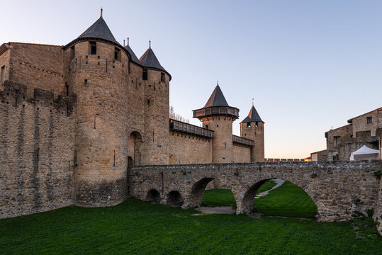 Fortified towers and curtain walls of Chateau Comtal inside the historic Cite de Carcassonne at dusk