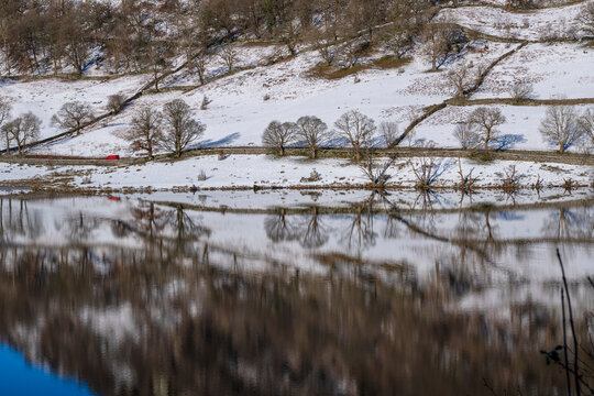 Reflections of snow covered hill at Rydal Water in the Lake District National Park, United Kingdom