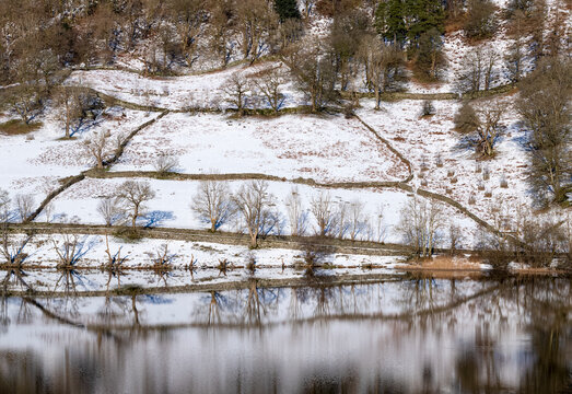 Reflections of snow covered hill at Rydal Water in the Lake District National Park, United Kingdom