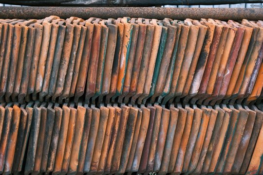 Arrangement of roof tiles outdoor. Aged and weathered. Genteng