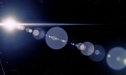 Abstract lens flare overlay with white light on dark background, vintage optical effect with blue bokeh for cinematic video editing and photo montage