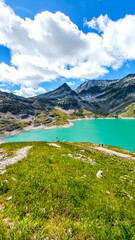Austria, 08-2025 : wide shot of Weißsee lake, mountains and glaciers in background. People hiking in front.