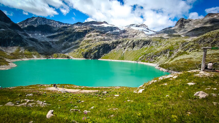 Austria, 08-2025 : wide shot of Weißsee lake, mountains and glaciers in background. People hiking in front.
