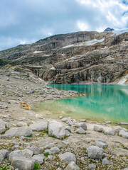 Austria, 08-2025 : wide shot of a glacial lake, near the weißsee lake. Moutains and cloudy sky in background.