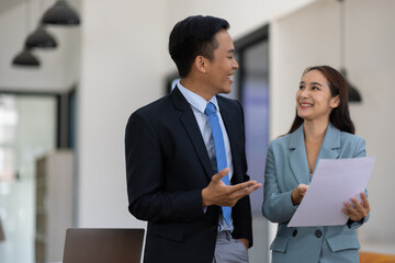 Coworkers standing and talking in the office.