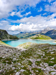Austria, 08-2025 : wide shot of Weißsee lake, mountains and glaciers in background, mountain rocks in foreground.