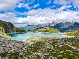 Austria, 08-2025 : wide shot of Weißsee lake, mountains and glaciers in background, mountain rocks in foreground.