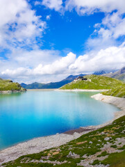 Austria, 08-2025 : wide shot of Weißsee lake, mountains, glaciers and cloudy blue sky in background