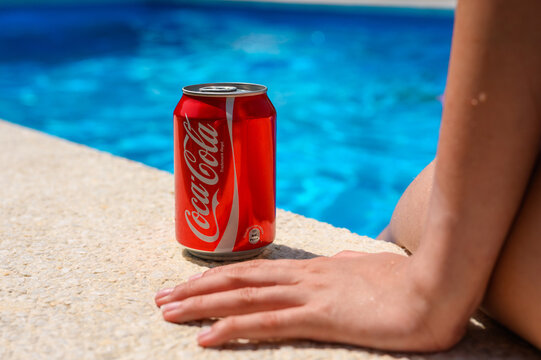 Anapa, Russia - July 13, 2025: Coca-Cola with a relaxing girl at the hotel pool. Refreshing drink on a summer day