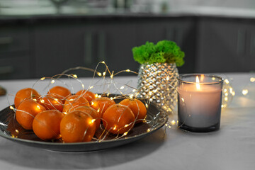 Festive still life with oranges and candle.