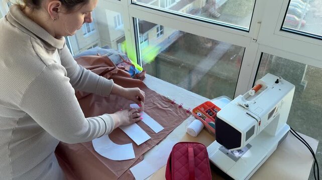 A fashionable woman using a sewing machine to craft clothing at home, with scissors and fabric all around, as a part-time entrepreneur.