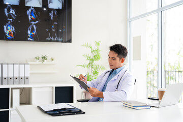 Professional doctor doing paperwork checking medical documents at workplace. Concentrated physician reading medic form analyzing patient diagnosis or report in hospital.