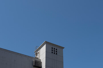 Minimalist concrete building tower against blue sky