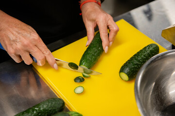 female hands cutting a cucumber