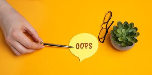Sticky note with OOPS. Human error, mistake at work, forgotten tasks, apology, or accidental action. A visual metaphor for imperfection, regret, and learning moments. Woman pointing at inscription