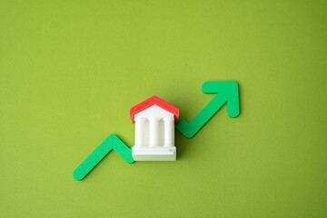 Bank building and green up arrow. Growth of savings in the bank account. Rising bank capitalization, deposit growth, increasing consumer savings. Business and finance