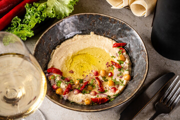 Hummus with olive oil, chickpeas, and herbs.