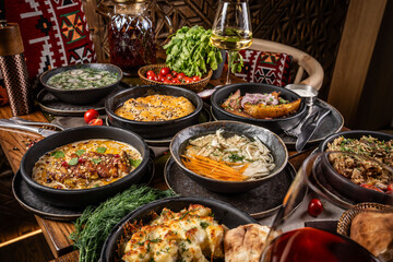 Traditional assorted dishes served on rustic restaurant table.