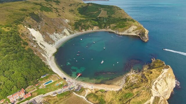 Descending orbital drone footage of the famous Lulworth Cove in Dorset, England