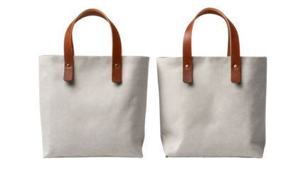 Two light gray canvas tote bags with tan leather handles 
