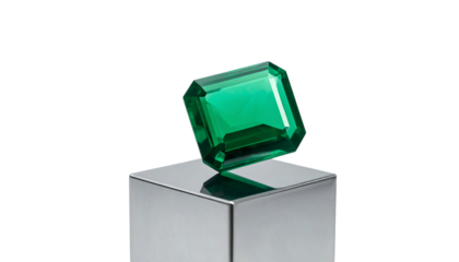 Emerald gemstone on a metallic cube isolated on white background.