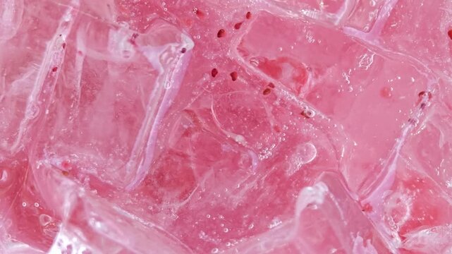 Ice cubes with bubbles of pink lemon soda.

