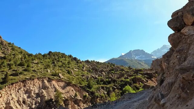 A narrow dirt winding road to inaccessible places in Tajikistan. The way to the Alaudinsky lakes. Dangerous rocky mountain road. The spirit of adventurism and adventure