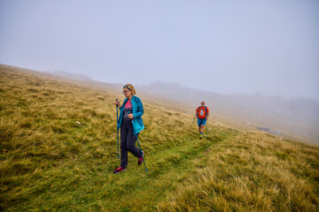 Obraz premium tourists on a mountain trail on a cloudy autumn day
