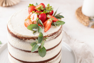 Appetizing semi-naked cake featuring creamy layers, fresh strawberries, and eucalyptus decor, perfect for any sweet celebration