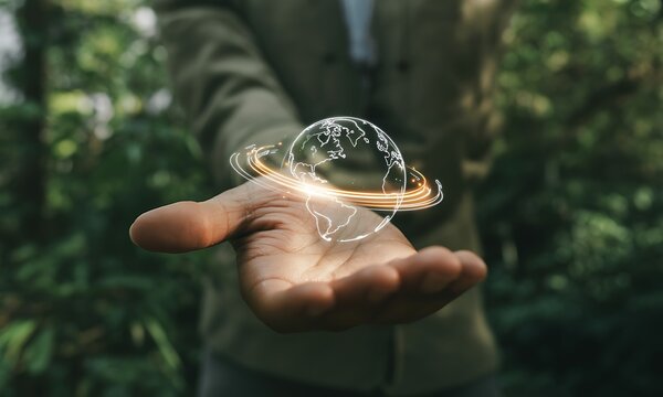 Human hand holding glowing digital Earth hologram with orbit lines, ideal for illustrating global connectivity, environmental awareness, and sustainable technology concepts