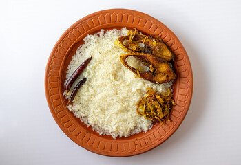 Panta Ilish, a classic Bengali dish. Panta bhat (fermented rice), fried Hilsa fish (Ilish bhaja), and chili served on a clay plate. Traditional Bangladeshi cuisine.