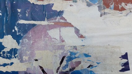 Old, torn, and ripped street poster, grungy background, weathered and abstract paper texture surface