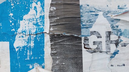 Old, torn, and ripped street poster, grungy background, weathered and abstract paper texture surface