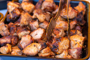 Metal tray with freshly grilled shashlik and serving tongs