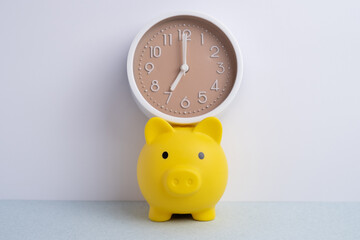 Piggy bank and alarm clock on a light background. Time to save, money, banking concept, finances. Space for text.
