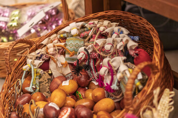 Traditional Ukrainian Easter eggs pysanky and folk dolls in wicker basket at holiday market