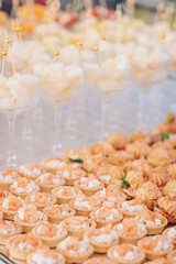 Delicious appetizers and elegant desserts create a lavish spread at a joyful celebration during the evening in a beautiful outdoor setting