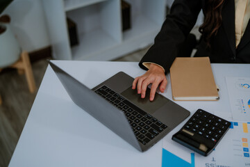 Focused businesswoman working at a desk with desktop computer in a bright office