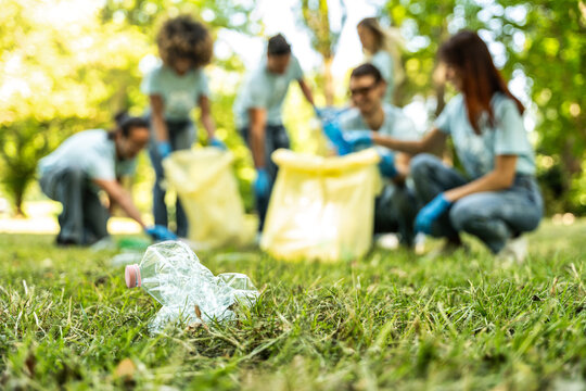 Group of volunteer cleaning picking up plastic litter in the park - Diverse group of people collect trash in the forest - Environmental protection, non profits organization and save the planet concept