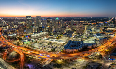 Obraz premium American city skyline of Tampa in Florida. Brightly illuminated commercial buildings and high speed highway road. Night urban landscape of downtown district in USA.