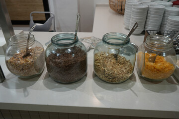 Assorted breakfast cereal varieties beautifully displayed in glass jars at a hotel buffet in Benidorm, Spain.