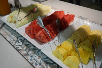 Fresh tropical fruit buffet featuring pineapple, watermelon, and melon slices at a hotel breakfast in Benidorm, Spain.
