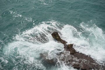 Scenic view of waves crashing on coastal rocks in Benidorm, Spain. Mediterranean Sea landscape in the summer.