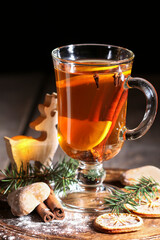Glass of Christmas tea with cloves, lemon and cinnamon sticks.