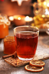 Glass of Christmas tea with cloves, lemon and cinnamon sticks.